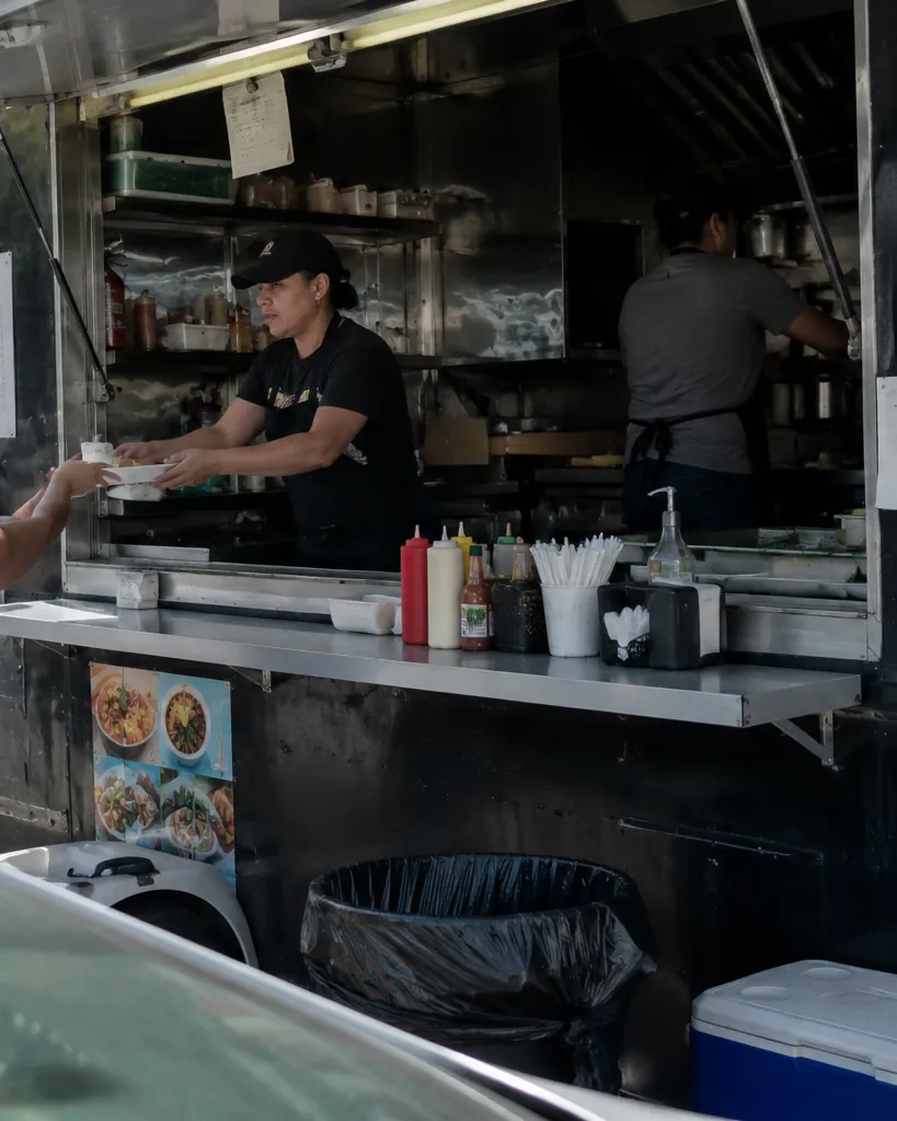 Cocinero atendiendo clientes por la ventanilla de un food truck